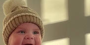 Maxi joined the competition — help win amazing prizes! baby, child, cozy, cute, green_toy, hands, happy, hat, indoor, infant, knit_hat, person, pom_pom, shadow, smiling, sunlight, tattoos, toy, wall, wearing