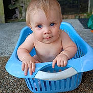 Maxi-Rangi is registered to the contest to win money with this photo: baby, child, blue_eyes, laundry_basket, plastic, hands, cute, curious, outdoor, ground, stone, skin, portrait, infant, baby_boy, sitting, expression, face, young_child, nature