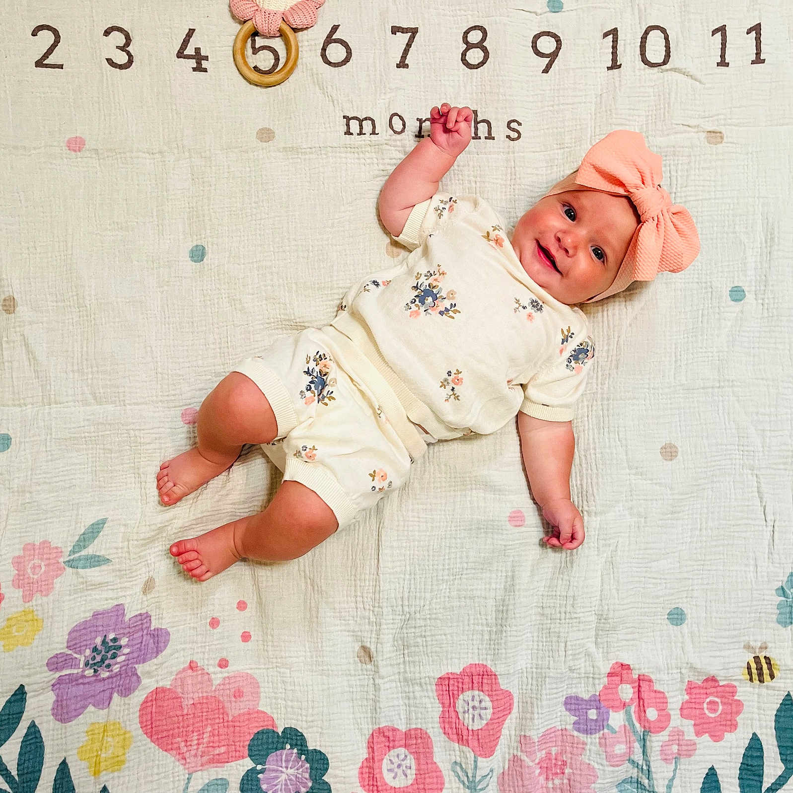 Brandi joined the competition — help win amazing prizes! baby, infant, smiling, floral_clothing, headband, pink_bow, blanket, numbers, months_marker, colorful, cute, lying_down, cheerful, skin, toes, pattern, celebration, milestone, baby_girl, decorative
