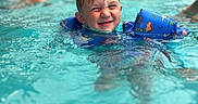 Wayland Bragg joined the competition — help win amazing prizes! child, pool, water, floaties, swimming, smile, wet_hair, splash, blue, dinosaur_pattern, fun, summer, recreation, people, background, outdoor, happy, play, swimwear, leisure