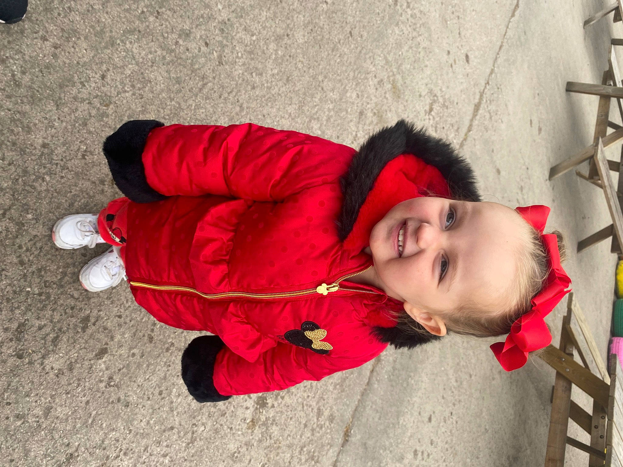 Scarlett-rose is registered to the contest to win money with this photo: baby, carmine, child, costume, flooring, fun, happy, joy, leisure, magenta, person, plant, red, road_surface, scarf, sidewalk, sitting, smile, toddler, tree