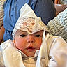 adorable, adult, baby, ceremony, child, closeup, cuddled, eyes, face, family, formalwear, indoor, infant, lace_bonnet, photography, portrait, satin, seated, soft_lighting, white_outfit