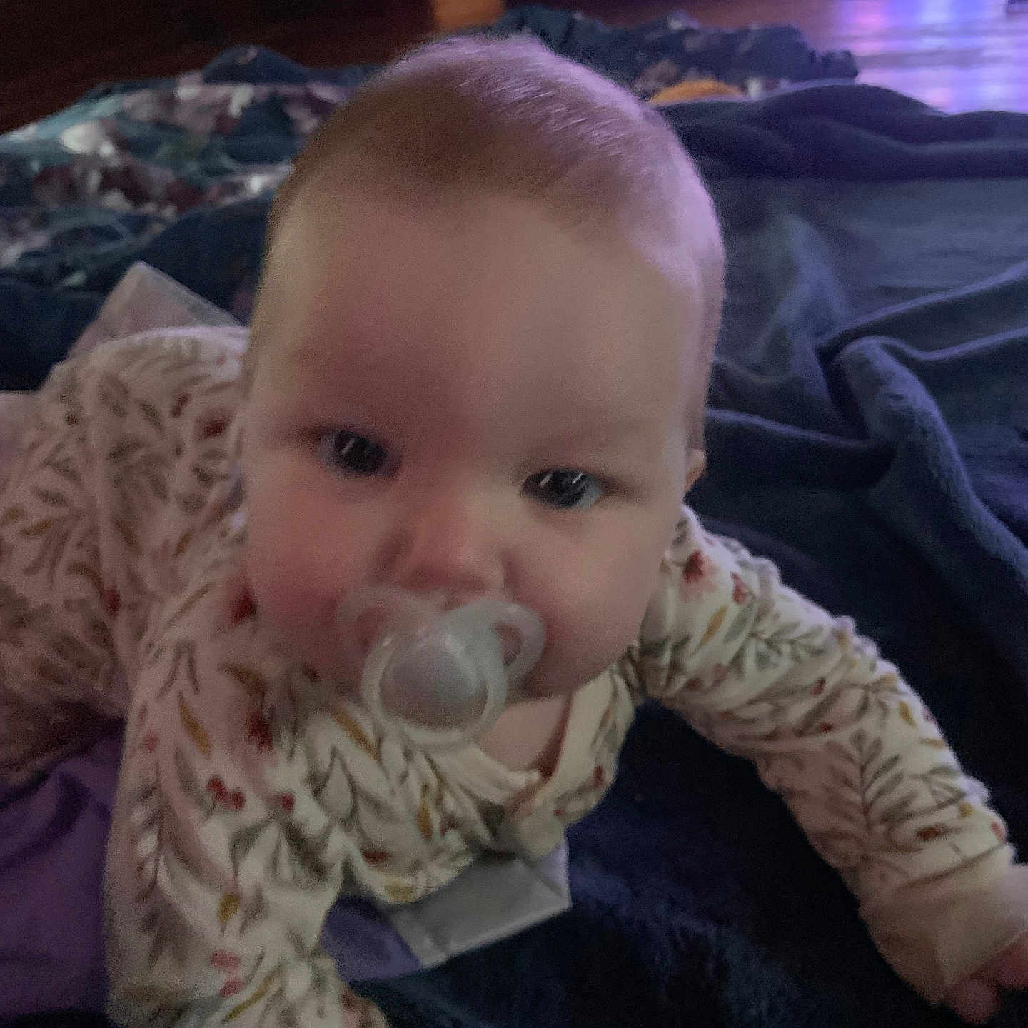 Agnes joined the competition — help win amazing prizes! baby, blanket, child, clothing, comfort, crawling, cute, face, floor, head, home, indoors, infant, pacifier, pajamas, person, room, soft_lighting, television, young