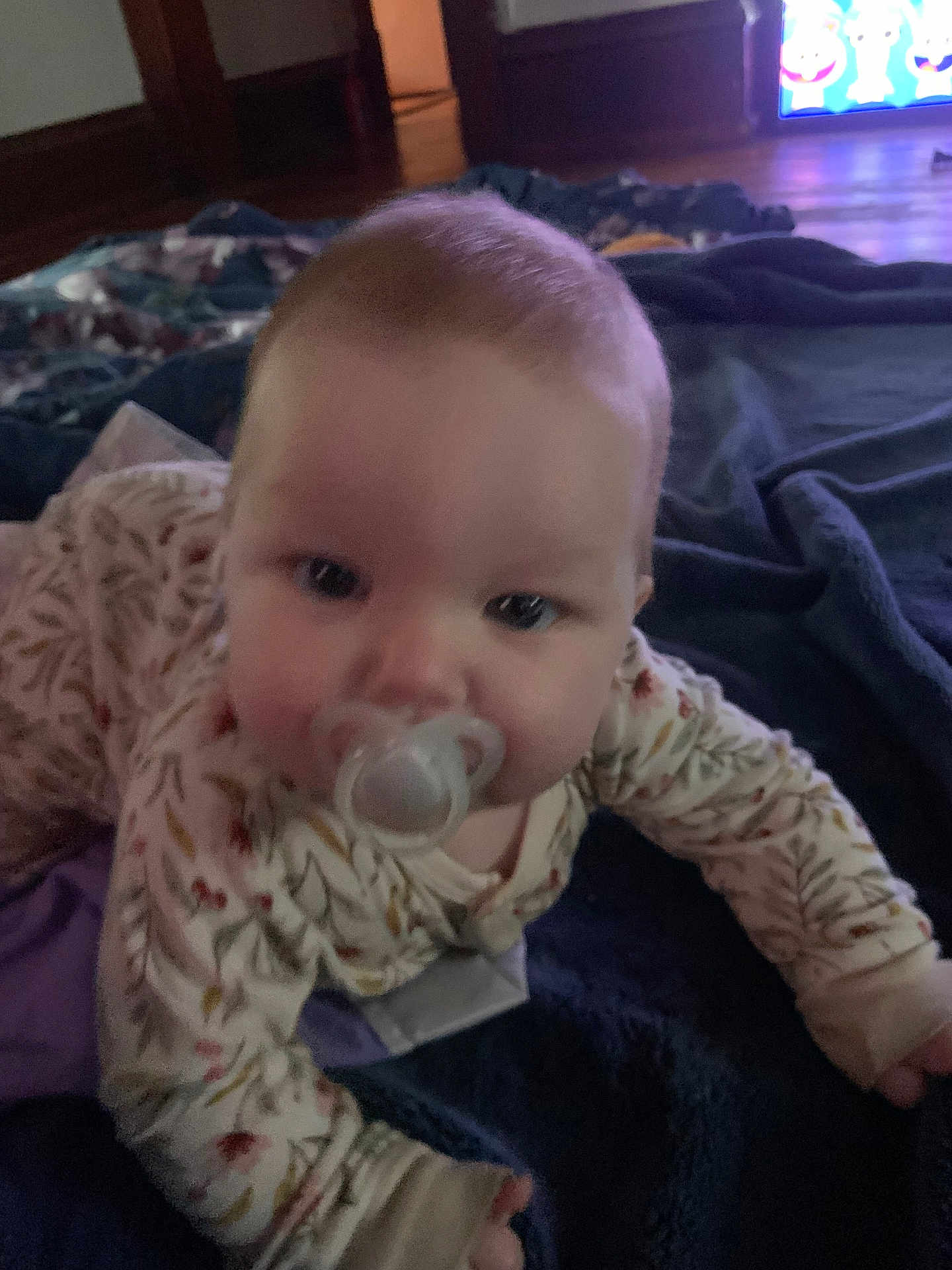 Agnes joined the competition — help win amazing prizes! baby, pacifier, infant, blanket, crawling, indoors, face, clothing, child, floor, television, room, soft_lighting, young, person, head, cute, comfort, pajamas, home