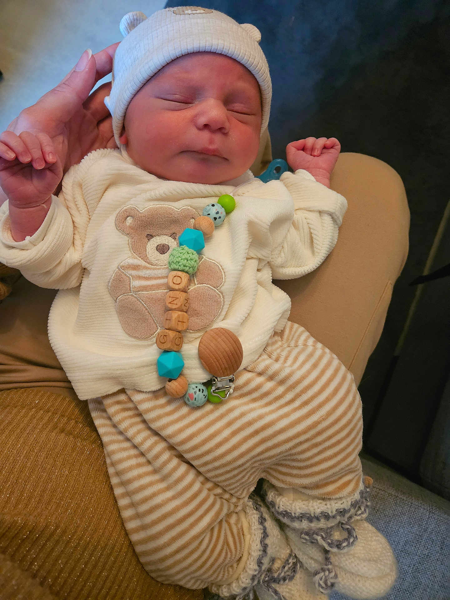 Gino participe au concours pour gagner de l'argent avec cette photo : baby, newborn, sleeping, hat, bear_ears, hand, striped_pants, knitted_booties, teddy_bear, clothing, person, infant, cute, soft_texture, indoor, holding, peaceful, closeup, warm_colors, cozy