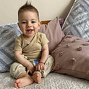 Stefan a rejoint le concours — aidez-le/la à gagner de superbes lots ! baby, child, smiling, sitting, bed, pillow, indoor, happy, cute, face, hair, clothing, foot, skin, infant, cozy, home, portrait, young, relaxed