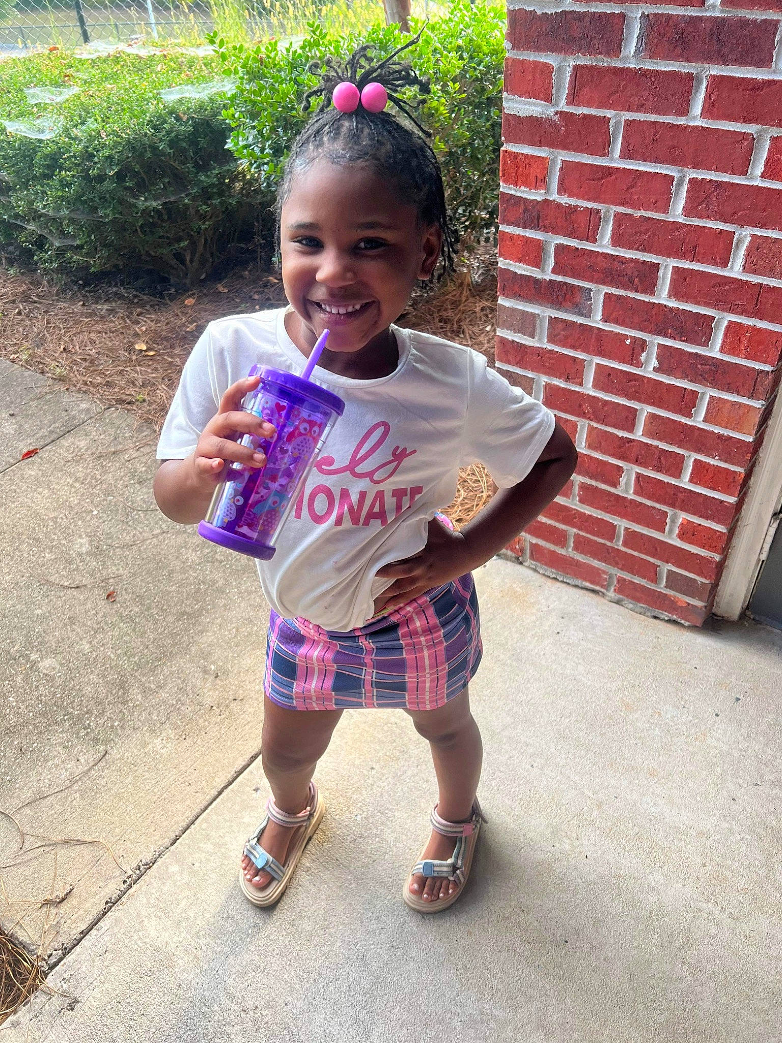 Zariyah is registered to the contest to win money with this photo: arm, baby_toddler_clothing, child, dress, face, fun, grass, hair, happy, head, joy, person, pink, plaid, plant, recreation, sleeve, smile, sock, t_shirt