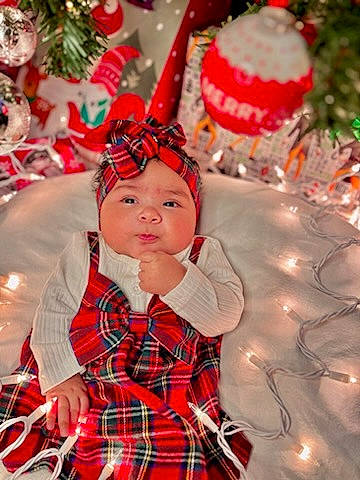 Dahlia joined the competition — help win amazing prizes! christmas, christmas_decoration, christmas_ornament, costume_hat, event, face, fun, happy, head, headgear, headwear, holiday, holiday_ornament, light, person, plaid, plant, red, sleeve, standing