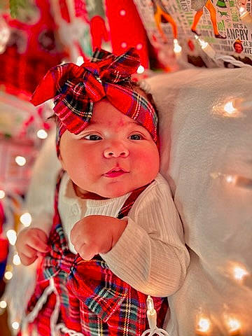 Dahlia joined the competition — help win amazing prizes! baby, baby_toddler_clothing, child, christmas, christmas_eve, costume_hat, event, face, facial_expression, fashion_accessory, fun, happy, headgear, headwear, holiday, pattern, person, plaid, red, tartan