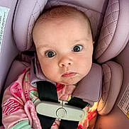 Everleigh is registered to the contest to win money with this photo: baby, infant, car_seat, pink, child, face, eyes, clothing, blanket, straps, seatbelt, cute, portrait, young, person, indoors, soft, cozy, fabric, head_support