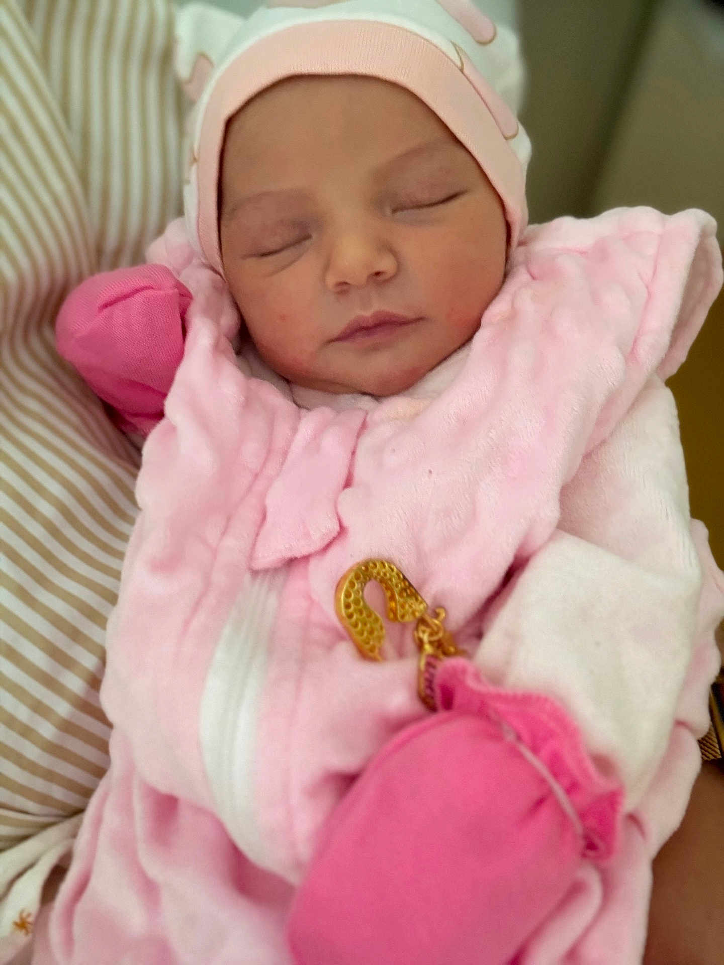 Ilyana a rejoint le concours — aidez-le/la à gagner de superbes lots ! newborn, baby, sleeping, pink_clothing, mittens, hat, soft_fabric, closeup, portrait, peaceful, infant, cute, cozy, striped_background, child, human, face, wrapped, resting, indoors
