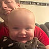 Osiris is registered to the contest to win money with this photo: baby, infant, child, adult, cuddling, selfie, portrait, smiling, happy, face, closeup, red_shirt, gray_clothing, indoor, couch, seated, family, parent, warm_lighting, home