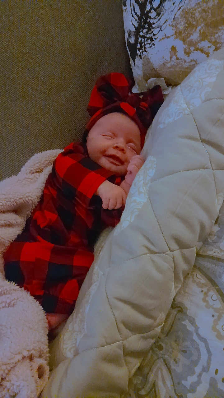 Timberlynn joined the competition — help win amazing prizes! baby, smiling, sleeping, red_and_black_checkered, headband, blanket, cushion, sofa, cozy, infant, cute, indoors, resting, soft, comfort, child, portrait, happy, clothing, relaxation