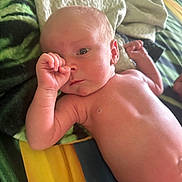 Arlo is registered to the contest to win money with this photo: baby, infant, thumb_sucking, blanket, colorful_blanket, skin, newborn, lying_down, bed, soft_texture, curious_expression, human, child, portrait, indoors, diaper, small_hand, head, face, resting