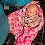 baby, blanket, clothing, cute, expression, face, grill, hand, holding, human, indoor, infant, metal, newborn, person, pink, sleeve, soft, support, wrapped