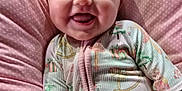 Remmie Kate is registered to the contest to win money with this photo: baby, smiling, infant, onesie, pink, cushion, polka_dot, happy, tongue_out, cute, child, portrait, soft, indoors, face, small_person, sleepwear, holiday_theme, lying_down, cozy