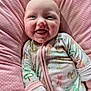 baby, smiling, infant, onesie, pink, cushion, polka_dot, happy, tongue_out, cute, child, portrait, soft, indoors, face, small_person, sleepwear, holiday_theme, lying_down, cozy