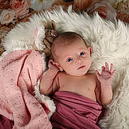 Théa a rejoint le concours — aidez-le/la à gagner de superbes lots ! baby, infant, blanket, soft_texture, fluffy_rug, knitted_toy, pink, mauve, flower_background, newborn, portrait, cute, hand, face, eyes, lying_down, cozy, warm, soft_lighting, indoor