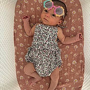 Azzurra a rejoint le concours — aidez-le/la à gagner de superbes lots ! baby, infant, sunglasses, flower_pattern, cushion, crib, mesh, sleepwear, cute, child, portrait, resting, indoor, newborn, fashion, pink, white, floral, accessory, relaxing