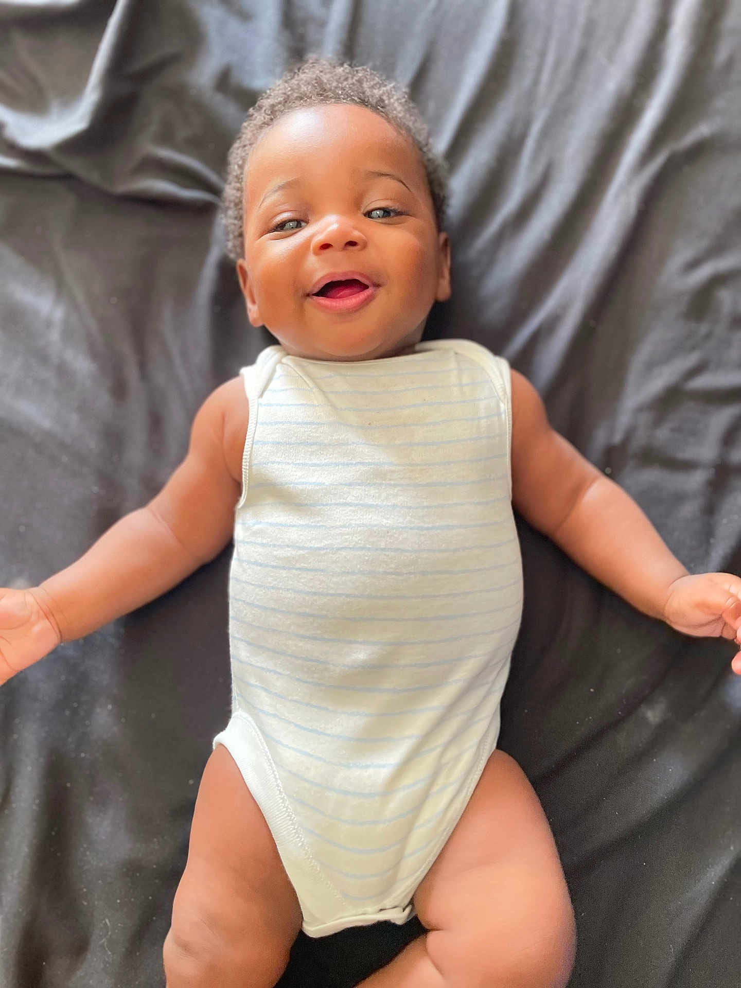 Isaac participe au concours pour gagner de l'argent avec cette photo : baby, smiling, infant, onesie, lying_down, happy, child, cute, skin, arms, legs, blanket, portrait, closeup, young, people, toddler, face, indoor, person