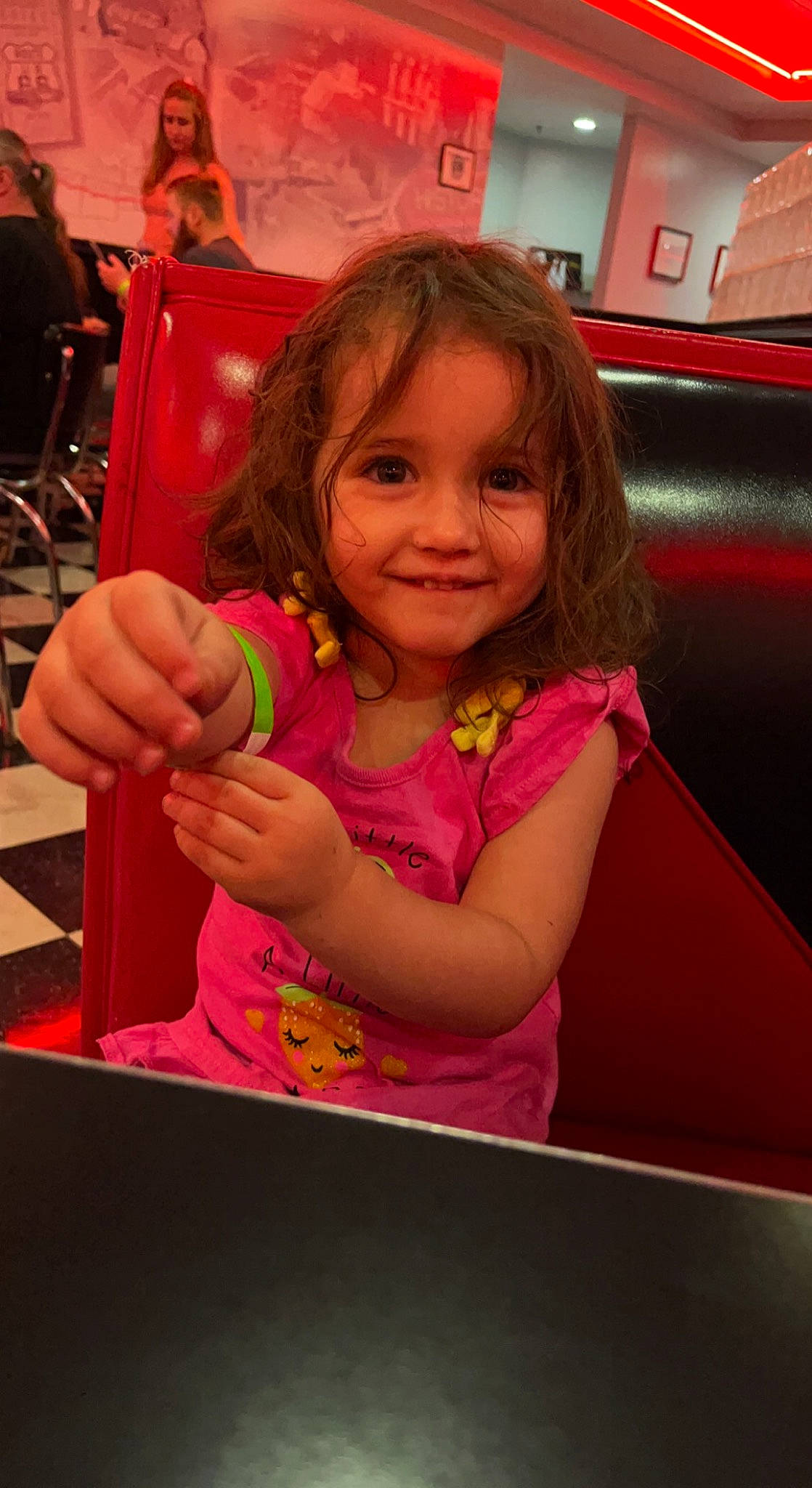 Sophie is registered to the contest to win money with this photo: child, facial_expression, finger, fun, hairstyle, happy, joy, leisure, magenta, person, pink, play, recreation, sitting, skin, smile, standing, t_shirt, thumb, toddler