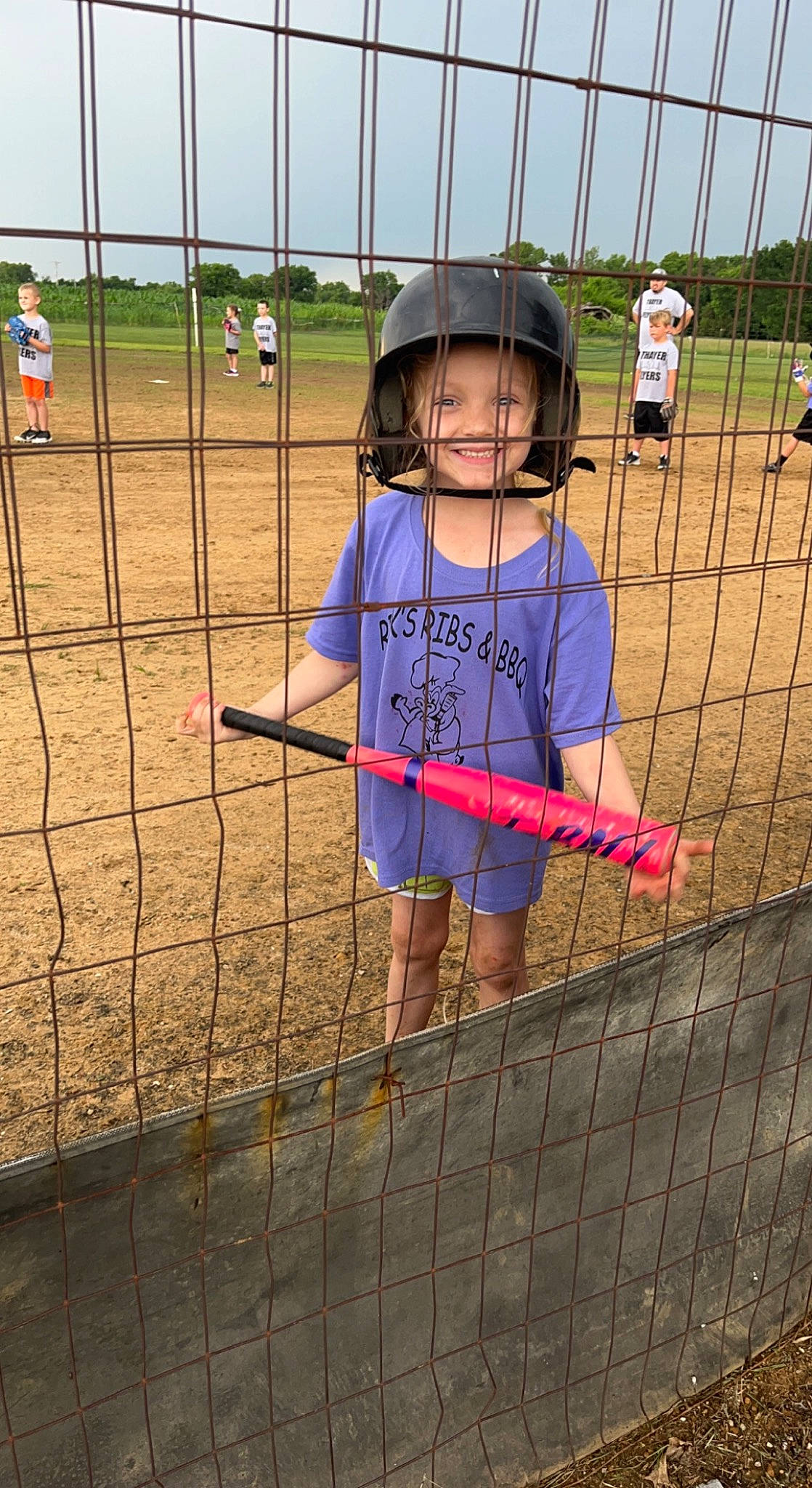 Kenzlie is registered to the contest to win money with this photo: city, fence, fun, grass, helmet, joy, landscape, leisure, mesh, net, person, player, recreation, shorts, sky, soil, sports_equipment, sports_gear, tire, toddler