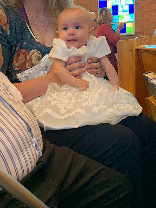 Lydia is registered to the contest to win money with this photo: baby, baby_toddler_clothing, chair, child, comfort, event, formal_wear, fun, gesture, gown, hairstyle, hand, happy, lap, person, room, sitting, skin, thumb, toddler