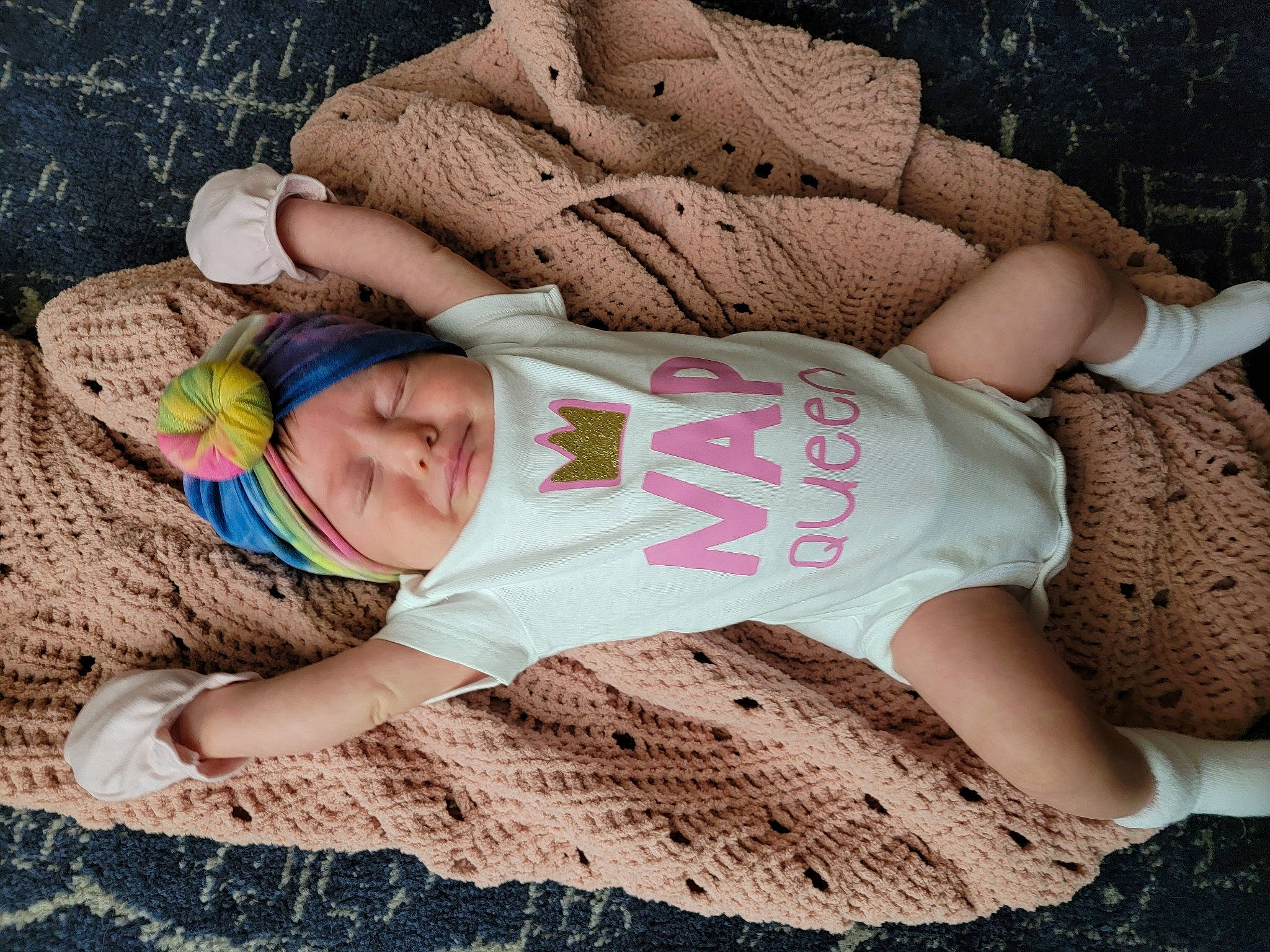 Estelle is registered to the contest to win money with this photo: arm, baby_toddler_clothing, comfort, cool, eye, finger, grass, hand, head, headgear, headwear, human_body, leg, person, pink, plant, product, skin, sleeve, textile