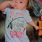 Anastasia is registered to the contest to win money with this photo: baby, infant, onesie, clothing, thumb_sucking, lying_down, blanket, face, expression, indoor, cute, child, person, soft_texture, colorful, book, toy, home, casual, relaxed