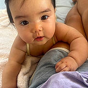 Mizuki joined the competition — help win amazing prizes! baby, infant, face, eyes, arm, hand, skin, towel, clothing, lap, person, closeup, cute, child, resting, indoors, soft, warm, curious, portrait