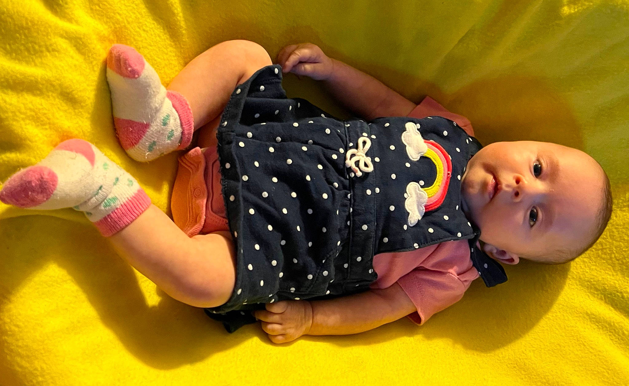 Sora is registered to the contest to win money with this photo: baby, baby_toddler_clothing, child, fun, hand, happy, human_leg, joint, knee, leg, nail, orange, pattern, person, pink, skin, sleeve, textile, thigh, toddler