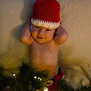 Pauly joined the competition — help win amazing prizes! baby, child, smiling, hat, crochet, blanket, christmas_lights, holiday, festive, greenery, infant, cute, portrait, laying_down, indoors, warm, happy, toddler, skin, hands