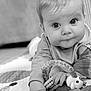 Ezra participe au concours pour gagner de l'argent avec cette photo : baby, infant, toy, giraffe_toy, quilt, black_and_white, child, cute, face, hand, eyes, clothing, indoor, floor, portrait, expression, play, young, person, closeup