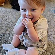 Hunter Allen is registered to the contest to win money with this photo: baby, child, toddler, sitting, smiling, happy, indoor, carpet, portrait, face, blue_eyes, blond_hair, white_socks, onesie, clothing, teddy_bear, toy_bag, home, floor, playful