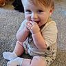 baby, child, toddler, sitting, smiling, happy, indoor, carpet, portrait, face, blue_eyes, blond_hair, white_socks, onesie, clothing, teddy_bear, toy_bag, home, floor, playful