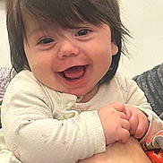 Ariana is registered to the contest to win money with this photo: baby, child, smiling, happy, face, hand, clothing, long_hair, indoor, person, infant, cute, joy, portrait, closeup, skin, sleeve, holding, watch, adult_hand