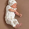 Elyjah is registered to the contest to win money with this photo: adorable, baby, barefoot, child, clothing, cozy, cute, hat, indoors, infant, lying_down, newborn, peaceful, portrait, resting, sleeping, small, soft, teddy_bear_pattern, white_outfit
