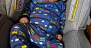 Elyjah is registered to the contest to win money with this photo: baby, blue_clothing, car_seat, child, comfortable, cute, fabric, face, footed_pajamas, head_support, indoor, infant, onesie, person, seat, sitting, skin, smile, train_pattern, young