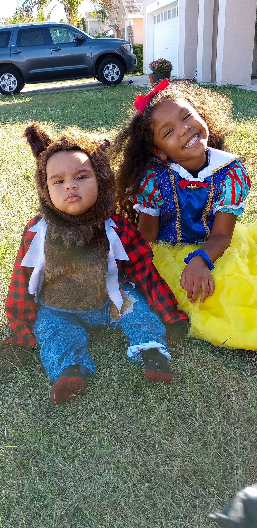 Zaniyah joined the competition — help win amazing prizes! child, costume, event, eye, face, fun, grass, hair, hairstyle, happy, head, joy, leisure, person, plant, recreation, sitting, smile, tire, toddler