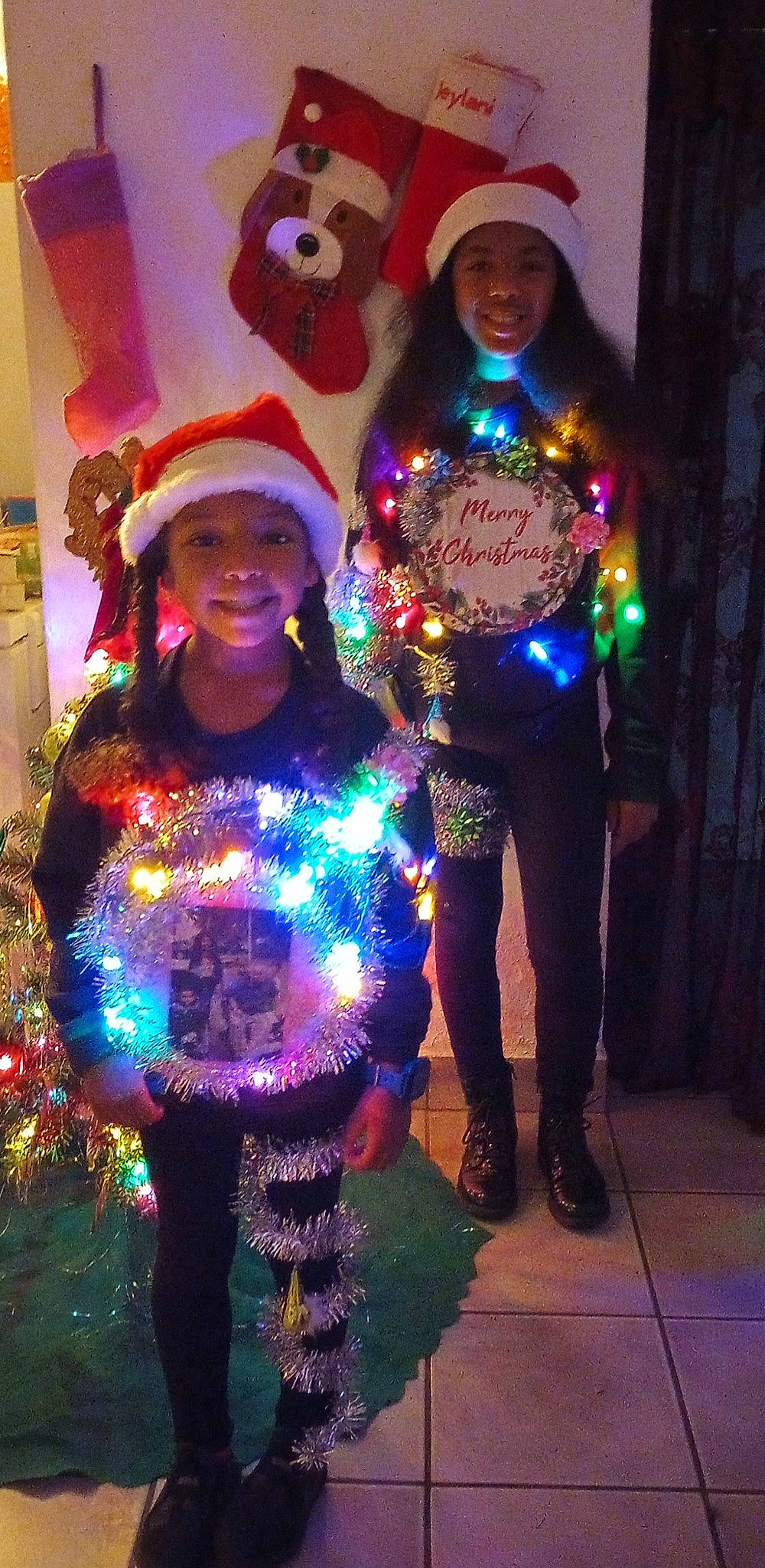 Zaniyah is registered to the contest to win money with this photo: christmas_decoration, christmas_ornament, electric_blue, entertainment, event, fun, happy, hat, headgear, headwear, holiday, joy, light, magenta, outerwear, party_supply, person, pink, plant, purple