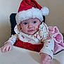 baby, child, santa_hat, holiday, christmas, high_chair, pink_blanket, festive_clothing, cute, infant, portrait, indoor, smiling, blue_eyes, long_sleeves, red_skirt, white_top, plush, happy, person