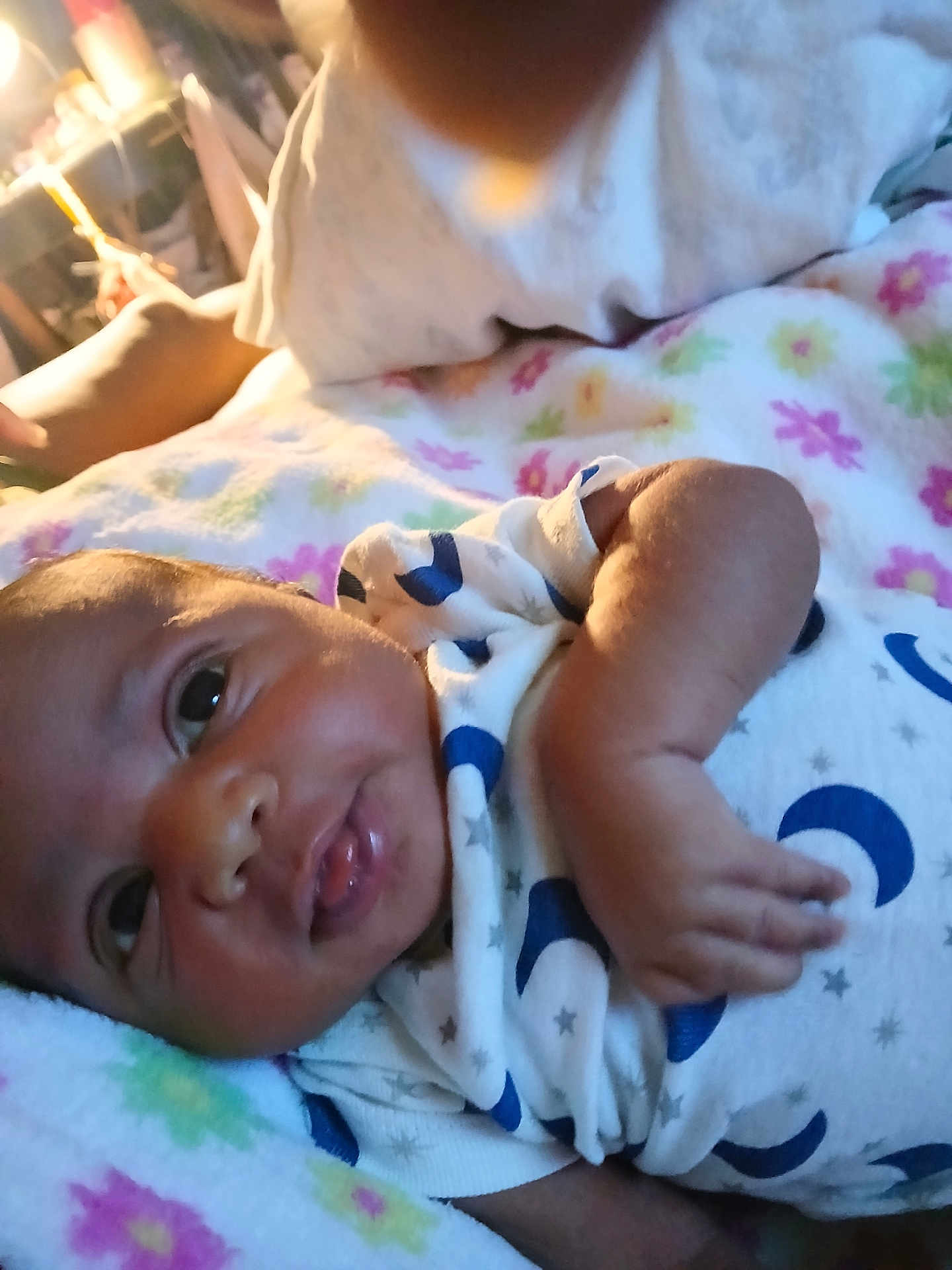 Grace is registered to the contest to win money with this photo: baby, infant, child, blanket, onesie, moon_pattern, stars_pattern, lying_down, close_up, cute, face, skin, hand, sleepwear, soft, colorful, indoors, portrait, newborn, expression