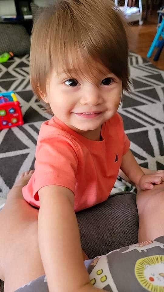 Elias is registered to the contest to win money with this photo: baby, baby_toddler_clothing, bangs, cheek, child, elbow, finger, flooring, fun, hairstyle, happy, human_body, joy, person, play, sitting, skin, sleeve, smile, t_shirt