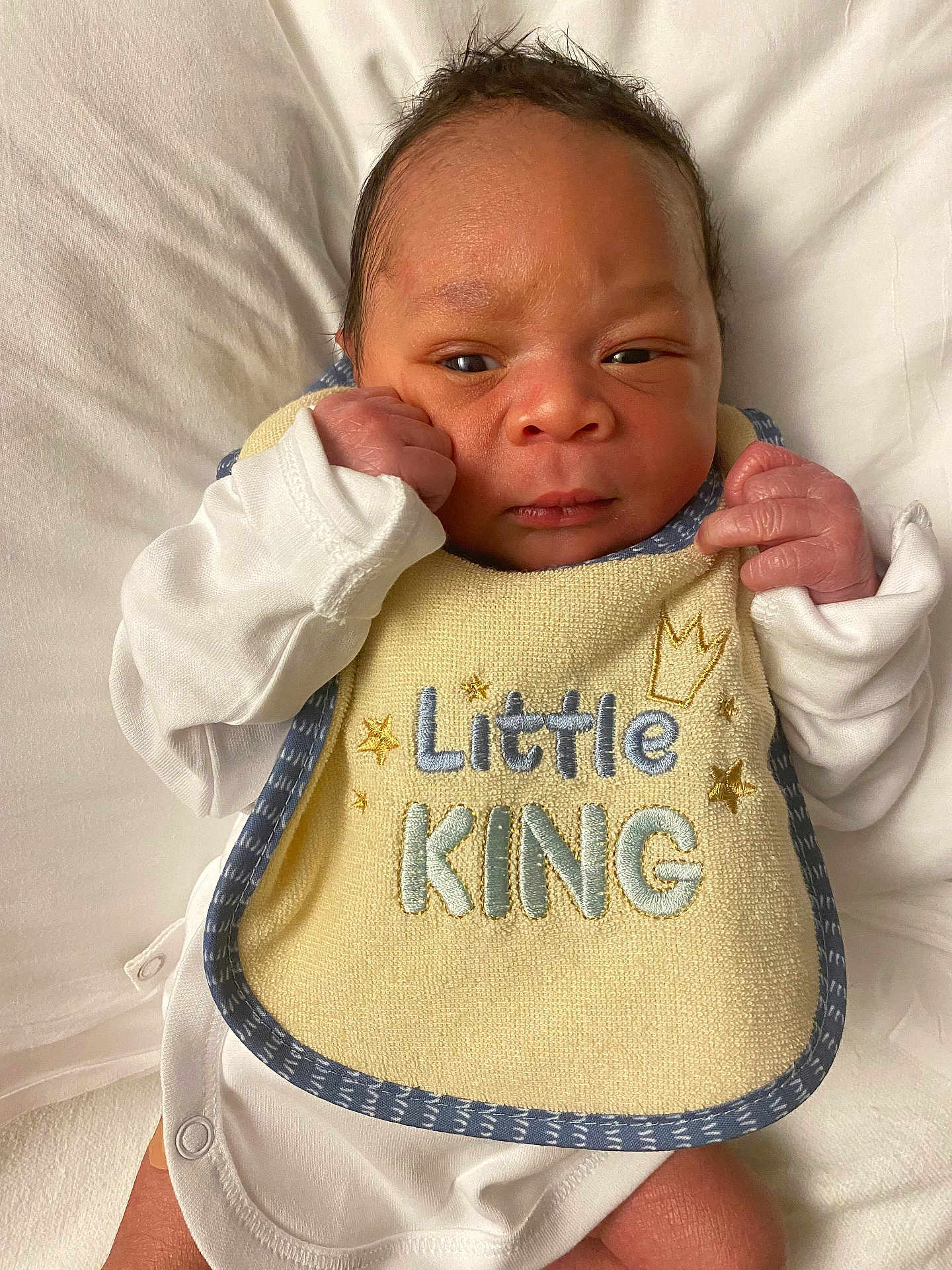 Leroi joined the competition — help win amazing prizes! baby, newborn, infant, bib, clothing, white, lying_down, face, hands, cute, portrait, soft, fabric, skin, head, small, expression, indoors, resting, child