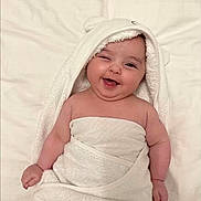 Samira a rejoint le concours — aidez-le/la à gagner de superbes lots ! baby, child, chubby, cute, face, fluffy, happy, hood, indoors, infant, lying_down, one_person, portrait, skin, smile, soft, towel, white, winking, wrapped