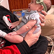 Cassandra is registered to the contest to win money with this photo: baby, child, headband, bow, smiling, person, arms, indoor, couch, furniture, wood_paneling, clothing, hand, holding, portrait, infant, cute, warm, happy, cozy