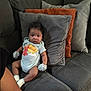 Javion is registered to the contest to win money with this photo: baby, infant, couch, pillows, mittens, onesie, elmo, clothing, seated, furniture, indoors, person, child, cute, expression, soft_furnishing, home, comfort, small_person, portrait