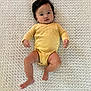 baby, infant, child, lying_down, yellow_onesie, blanket, texture, cute, face, skin, hair, indoor, newborn, portrait, smiling, small_hands, small_feet, soft_light, person, toddler