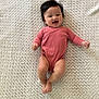 baby, infant, smiling, happy, lying_down, pink_onesie, blanket, texture, soft_light, cute, child, portrait, indoors, baby_clothing, young_child, human, skin, hair, expression, joyful