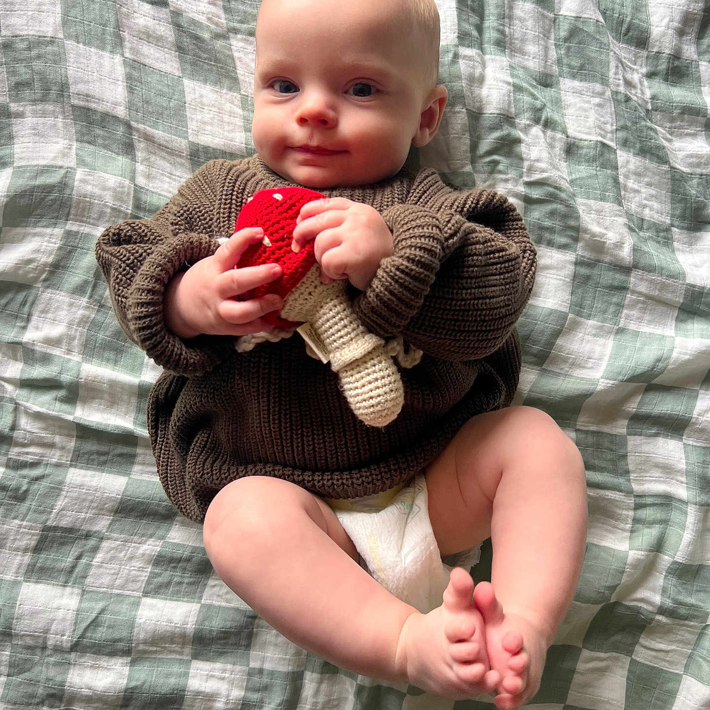 Forrest is registered to the contest to win money with this photo: baby, blanket, bodypart, clothing, couch, face, finger, furniture, hand, happy, head, knitwear, newborn, pants, person, photography, portrait, quilt, sitting, sweater